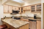 Upgraded kitchen has granite countertops and stainless steel appliances